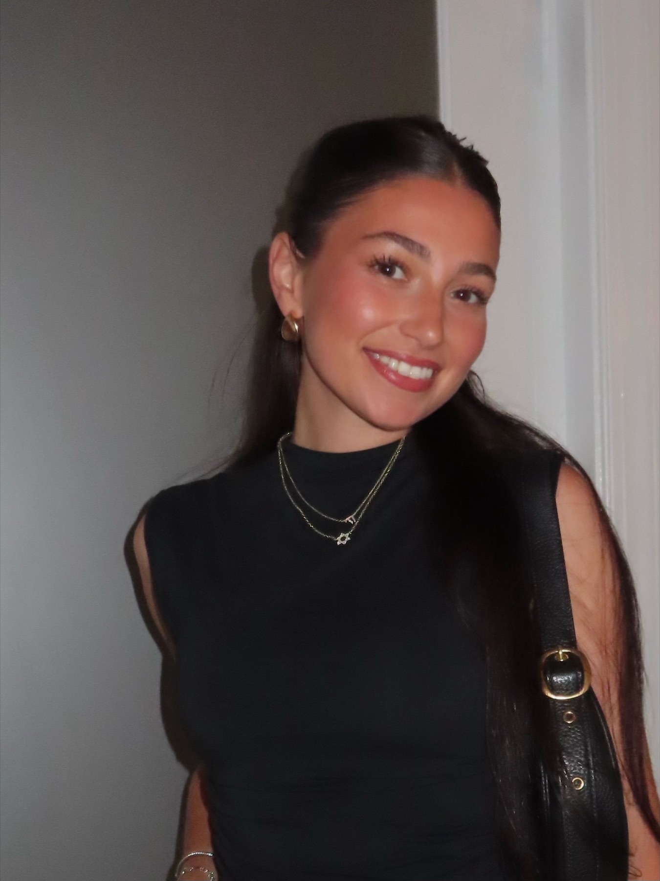 Elizabeth Goodman smiling in a black top and cream skirt